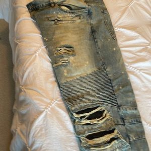 Washed denim with light blotches. Rips with navy fabric beneath.